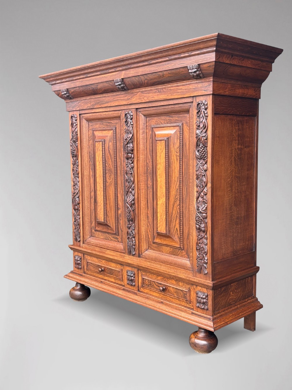 A 19th-century rosewood Renaissance Revival cabinet featuring relief foliage borders, fielded double doors, two lower drawers, and spherical bun feet. View II