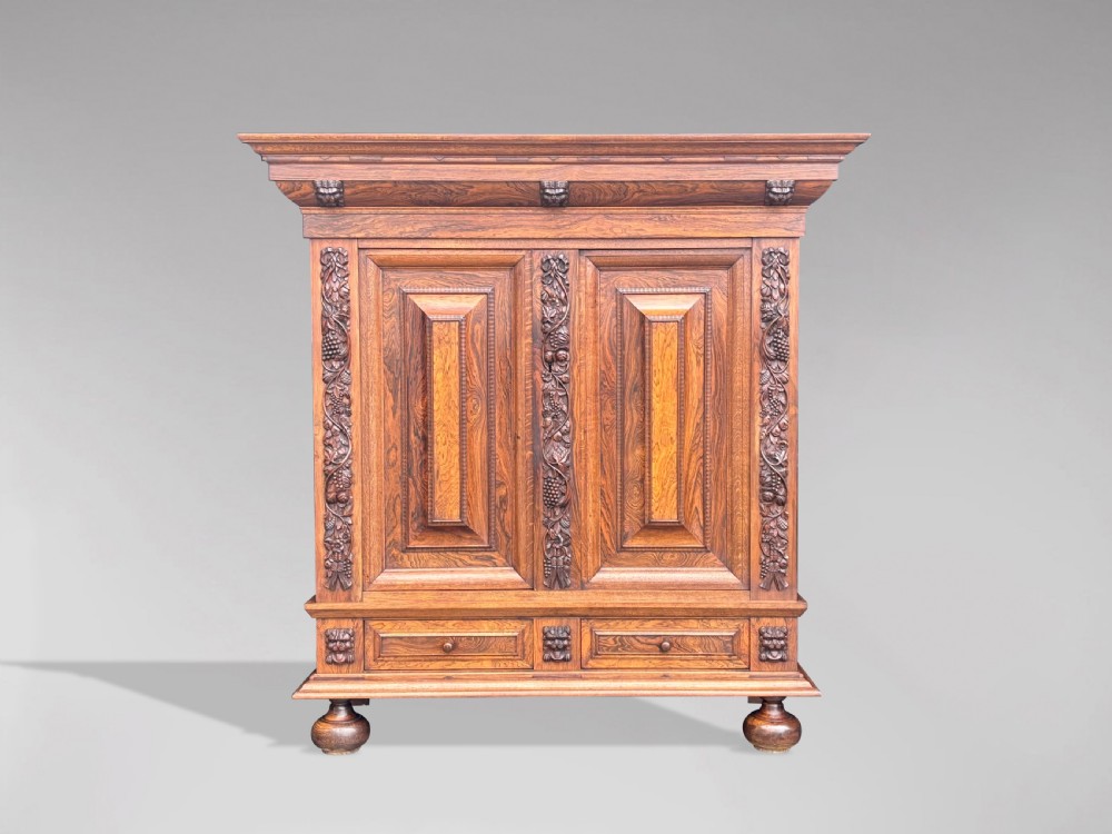 A 19th-century rosewood Renaissance Revival cabinet featuring relief foliage borders, fielded double doors, two lower drawers, and spherical bun feet. View III