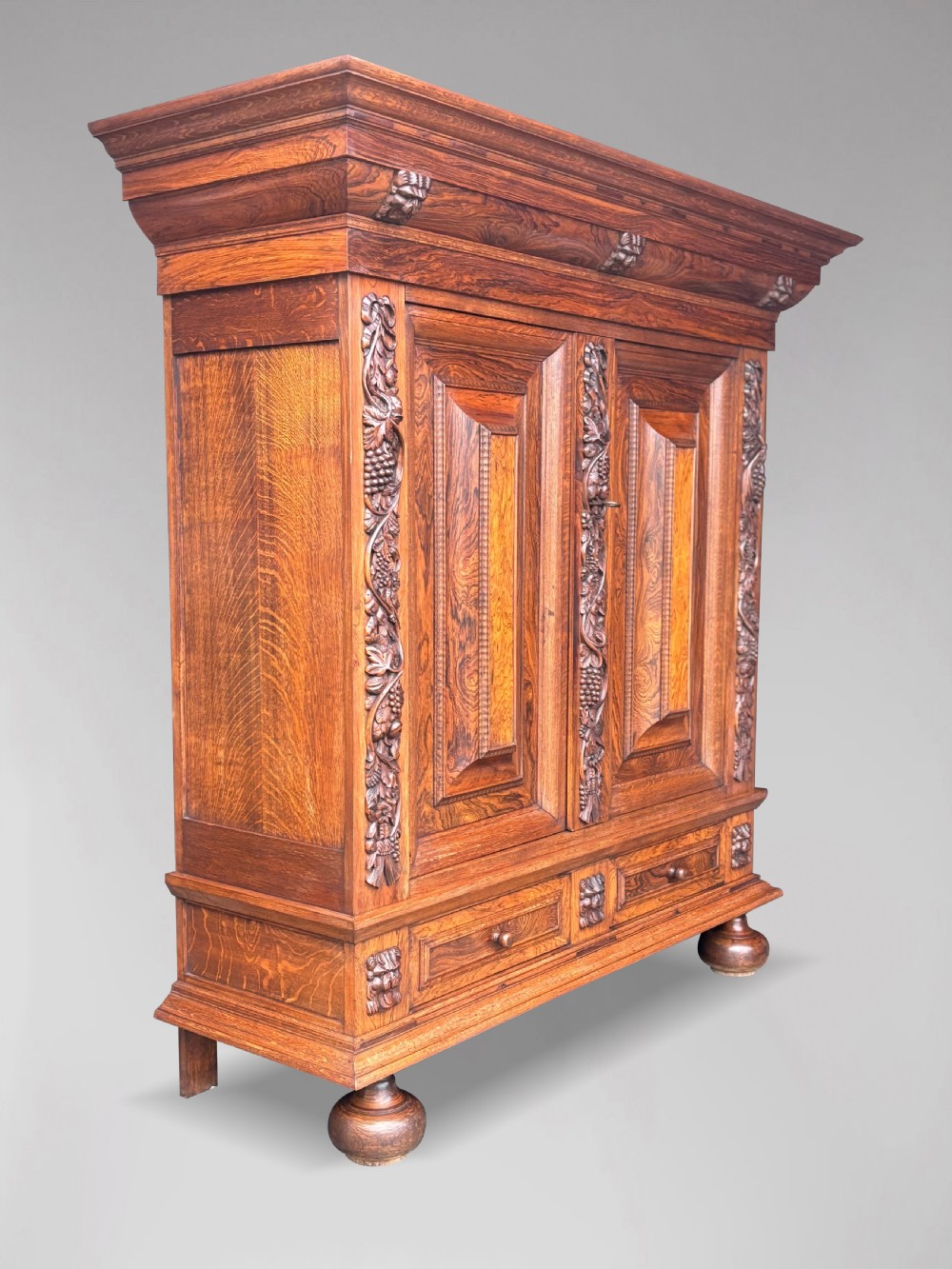 A 19th-century rosewood Renaissance Revival cabinet featuring relief foliage borders, fielded double doors, two lower drawers, and spherical bun feet. View IV