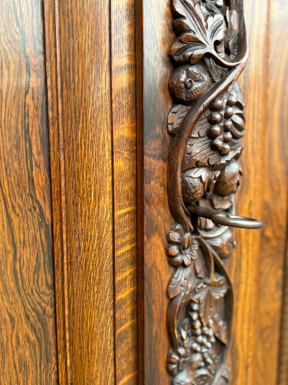 A 19th-century rosewood Renaissance Revival cabinet featuring relief foliage borders, fielded double doors, two lower drawers, and spherical bun feet. View V