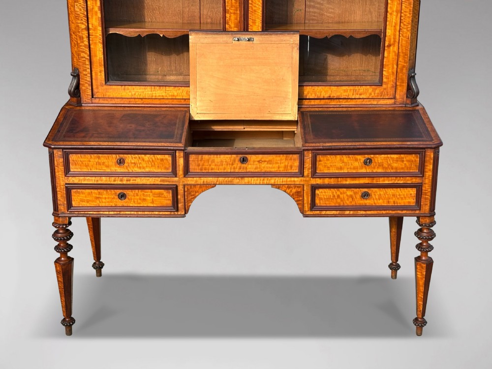 A 19th-century French maple bureau bookcase featuring a top glazed two-door display section above a kneehole writing desk with leather inset panels and turned legs. View V