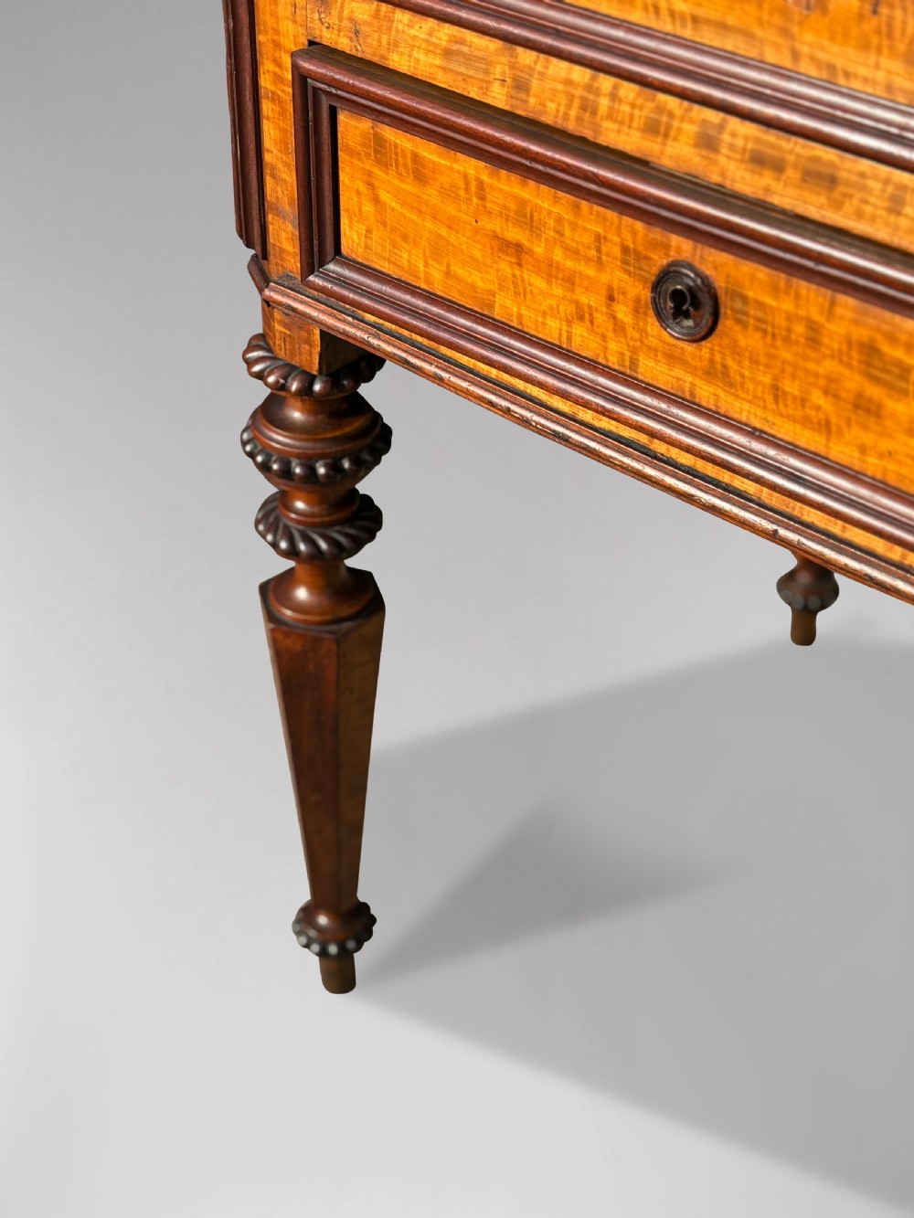A 19th-century French maple bureau bookcase featuring a top glazed two-door display section above a kneehole writing desk with leather inset panels and turned legs. View VII