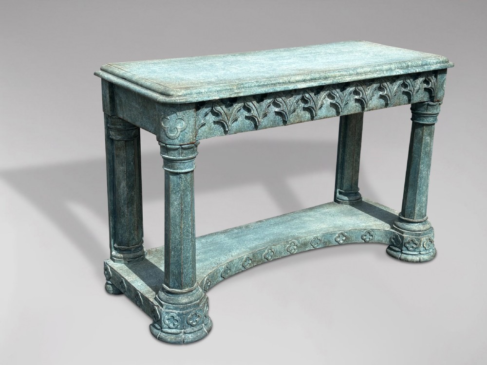 A 19th-century Gothic Revival console table with a distressed teal-green painted finish, carved tracery frieze, and column legs.