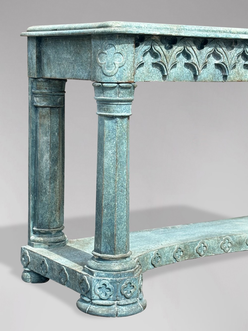 A 19th-century Gothic Revival console table with a distressed teal-green painted finish, carved tracery frieze, and column legs. View IV