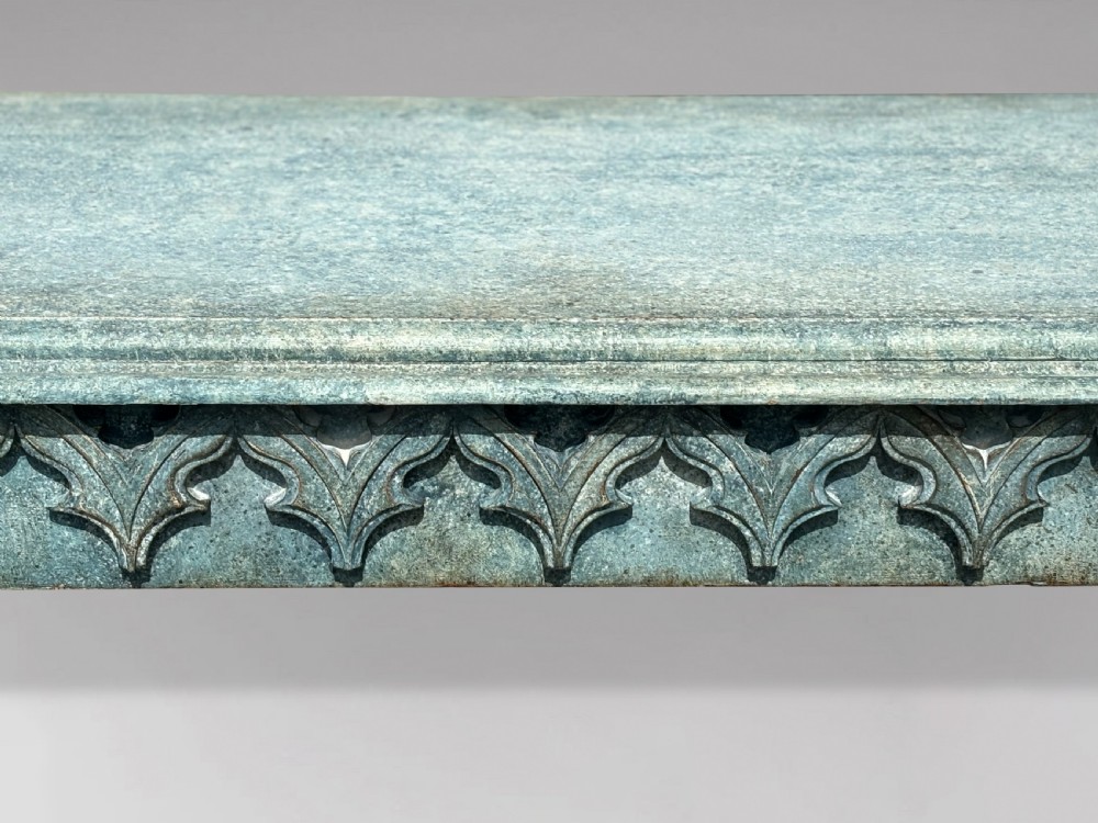 A 19th-century Gothic Revival console table with a distressed teal-green painted finish, carved tracery frieze, and column legs. View V