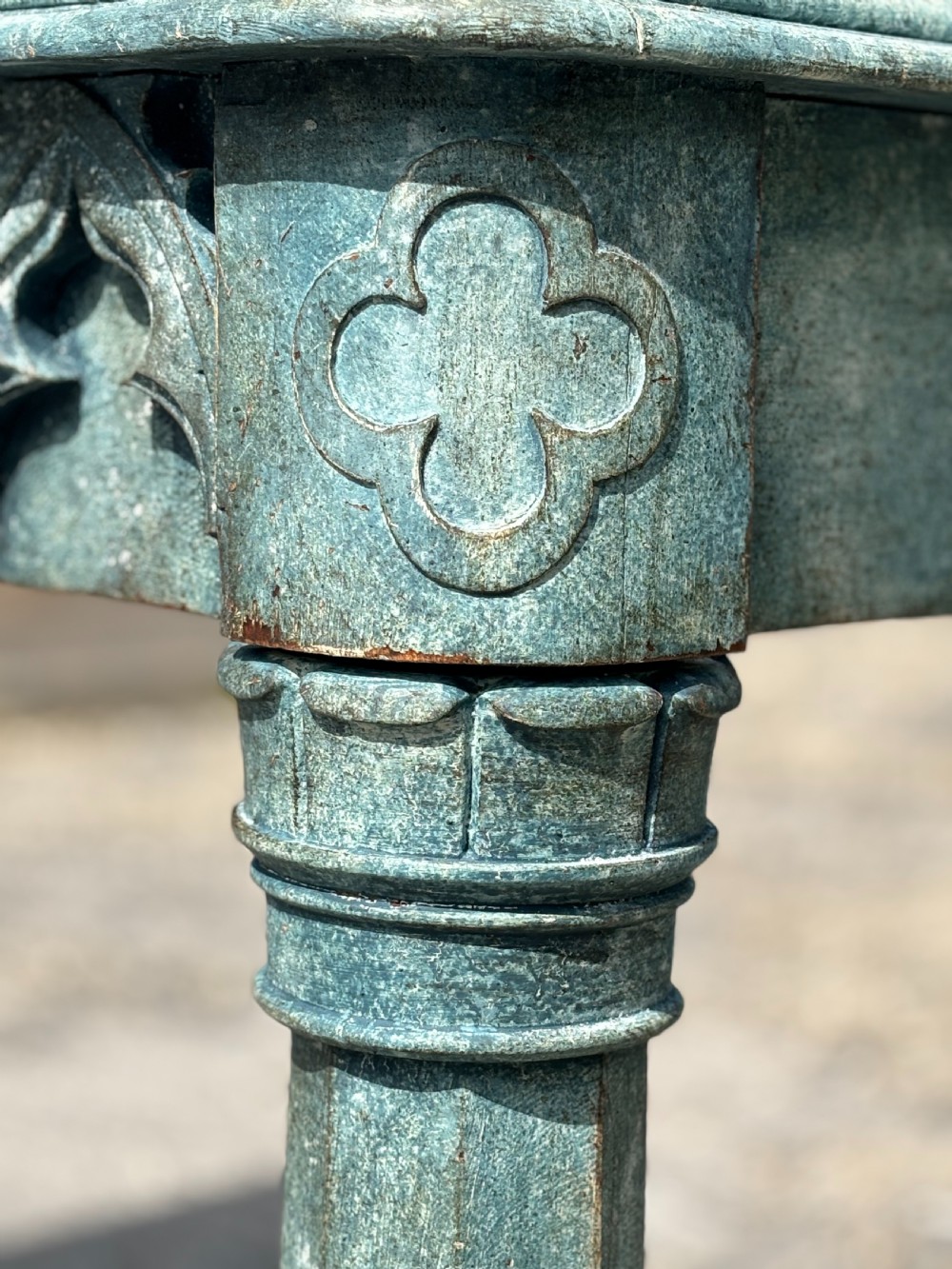 A 19th-century Gothic Revival console table with a distressed teal-green painted finish, carved tracery frieze, and column legs. View VII