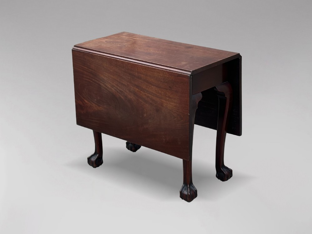 An 18th-century George II mahogany drop-leaf table featuring two hinged leaves, cabriole legs, and carved claw and ball feet.