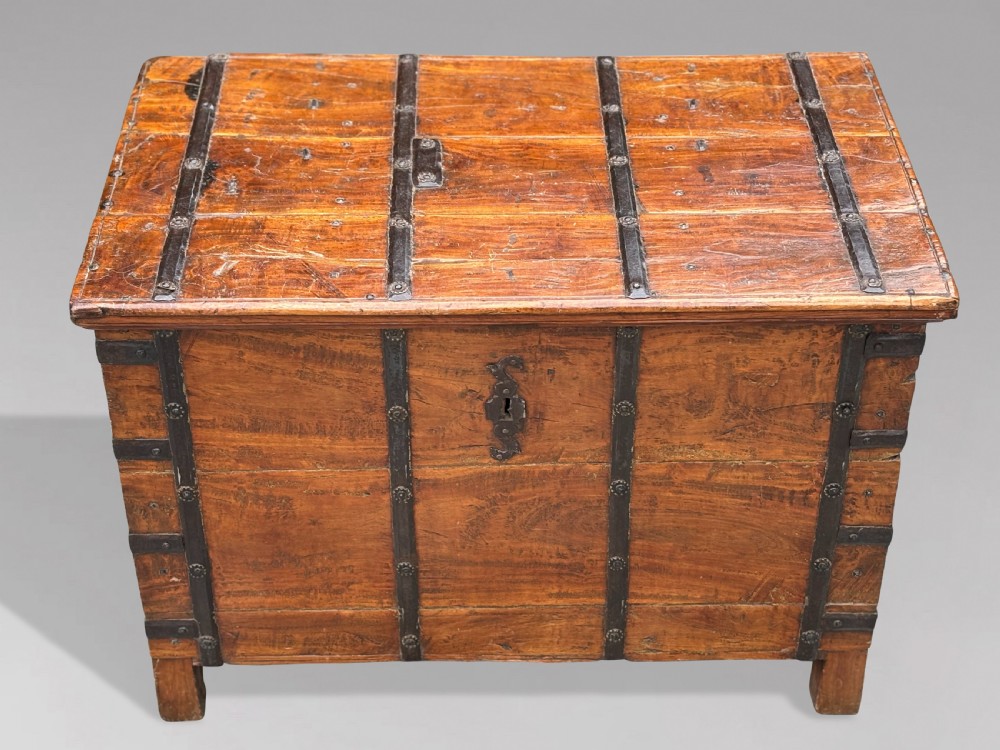 A nineteenth-century Anglo-Indian teak storage trunk featuring heavy iron banding, iron side carrying handles, and an aged timber patina. View II