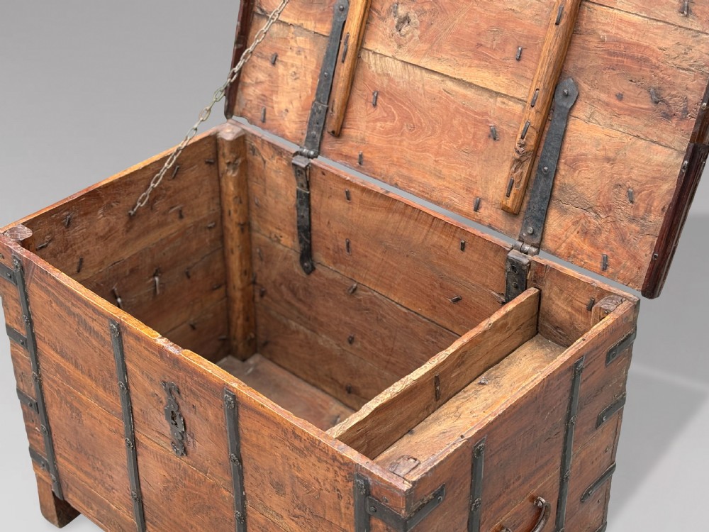 A nineteenth-century Anglo-Indian teak storage trunk featuring heavy iron banding, iron side carrying handles, and an aged timber patina. View IV
