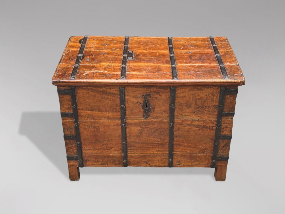 A nineteenth-century Anglo-Indian teak storage trunk featuring heavy iron banding, iron side carrying handles, and an aged timber patina. View IX