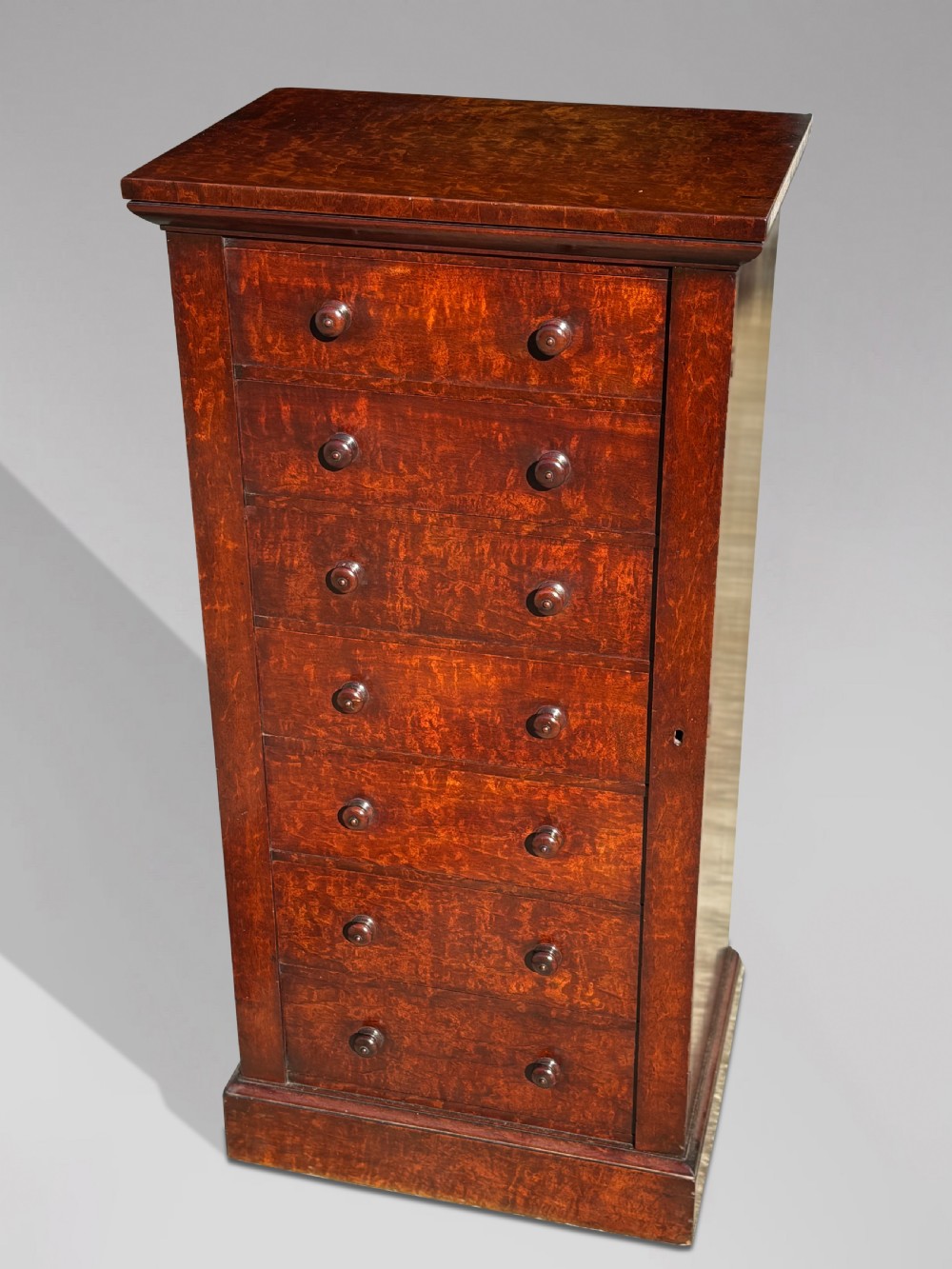 A tall 19th-century Georgian mahogany Wellington chest featuring seven graduated drawers with turned knobs and a hinged side locking flap. View III