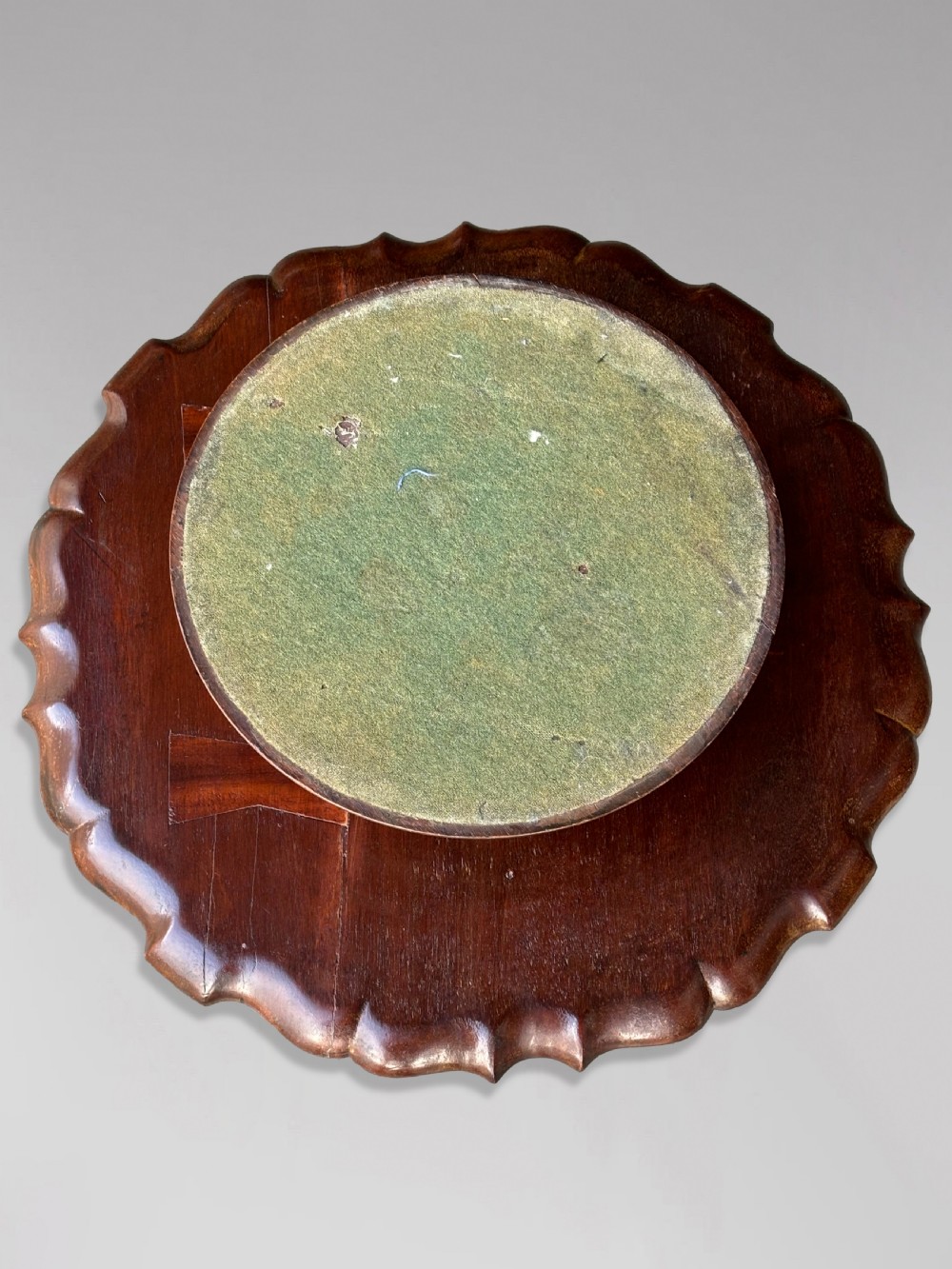 A 19th-century dark brown mahogany two-tier revolving Lazy Susan featuring scalloped piecrust rims and a turned, carved central column. View V