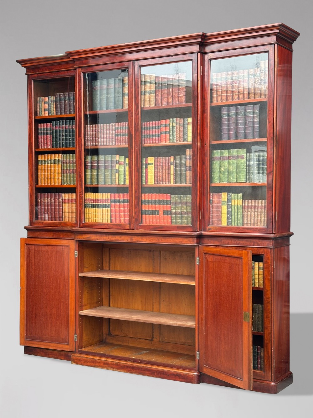 A large mid-nineteenth-century mahogany breakfront library bookcase featuring glazed upper doors, panelled lower cupboard doors, and a stepped moulded cornice. View II