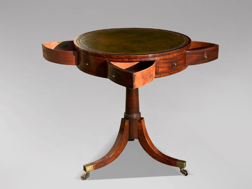 An 18th-century George III mahogany drum table with a circular green leather top, frieze drawers, turned pedestal, and splayed legs with brass castors. View VI