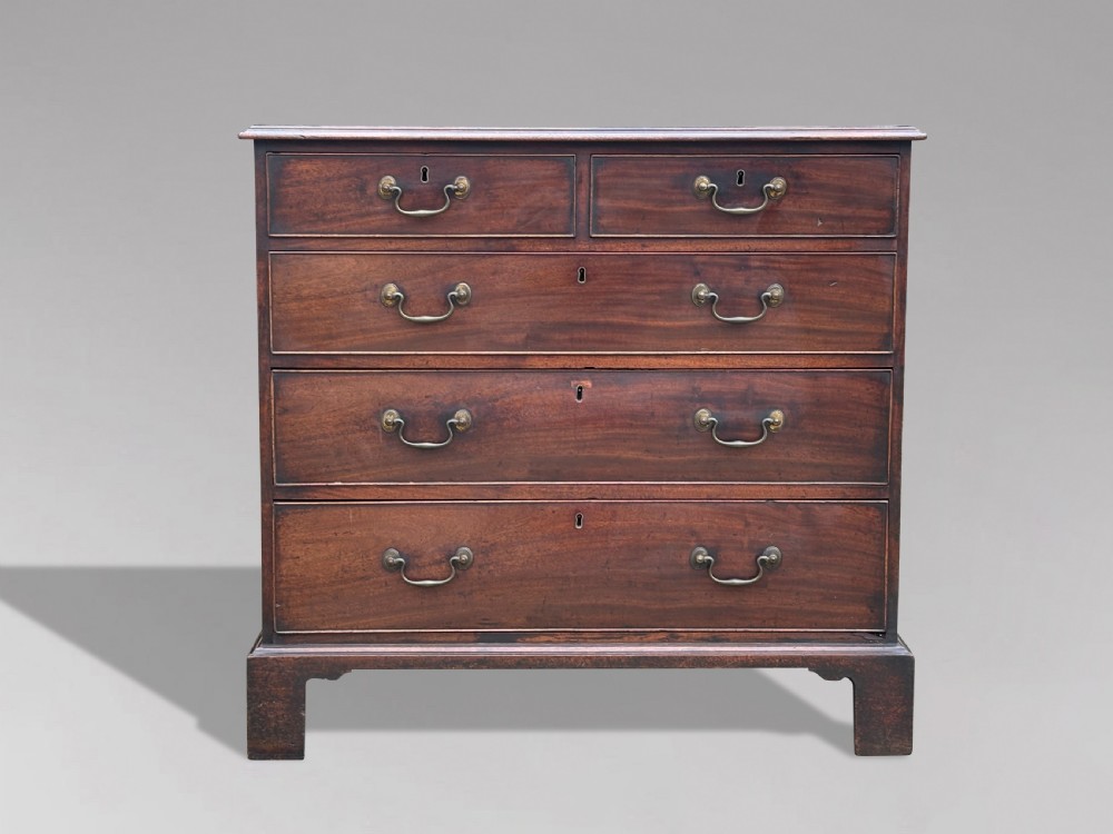 An 18th-century George III mahogany chest of drawers featuring two short over three long graduated drawers with brass swan-neck handles and bracket feet. View II