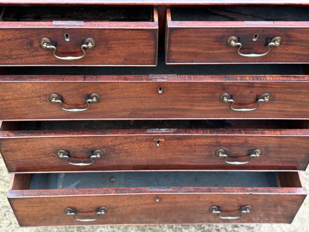 An 18th-century George III mahogany chest of drawers featuring two short over three long graduated drawers with brass swan-neck handles and bracket feet. View III