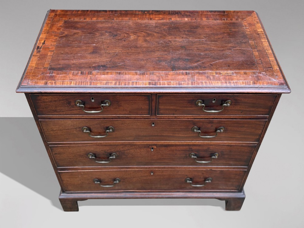 An 18th-century George III mahogany chest of drawers featuring two short over three long graduated drawers with brass swan-neck handles and bracket feet. View V