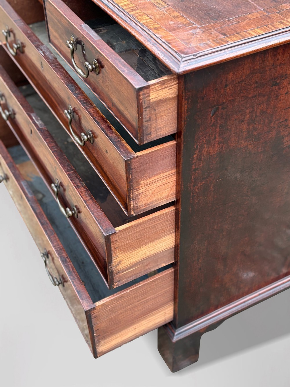 An 18th-century George III mahogany chest of drawers featuring two short over three long graduated drawers with brass swan-neck handles and bracket feet. View VI