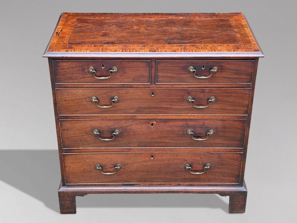 An 18th-century George III mahogany chest of drawers featuring two short over three long graduated drawers with brass swan-neck handles and bracket feet. View VII