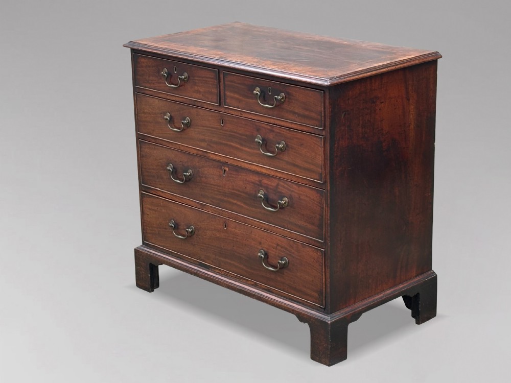 An 18th-century George III mahogany chest of drawers featuring two short over three long graduated drawers with brass swan-neck handles and bracket feet. View VIII