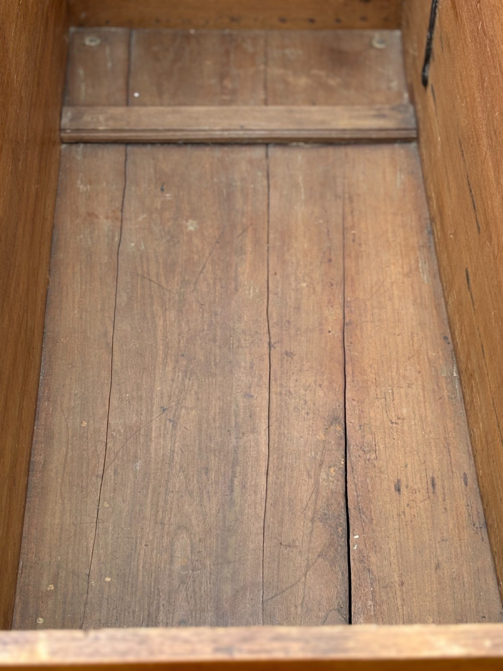 An 18th-century warm brown walnut colonial chest featuring brass corner brackets, a central decorative brass escutcheon, lid studs, and dark turned bun feet. View VI