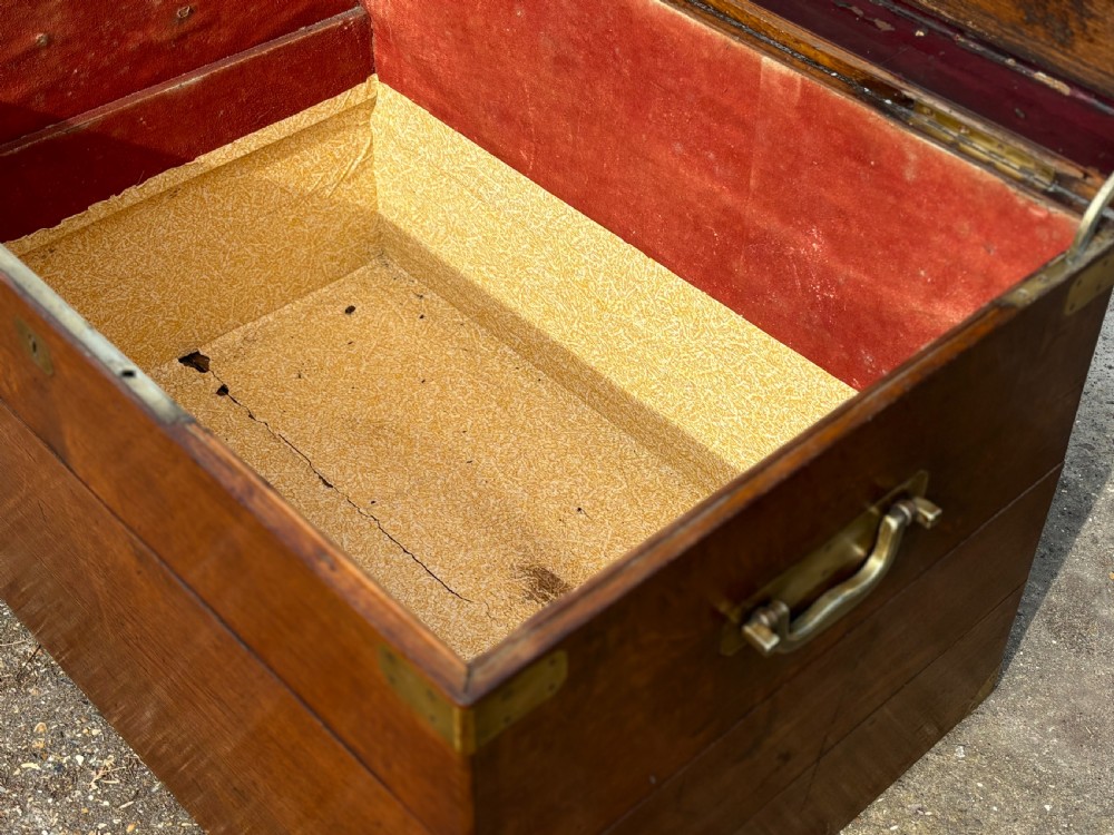 A large rectangular 19th-century oak travelling trunk featuring brass corner mounts, drop side handles, and an inlaid lid cartouche. View VI