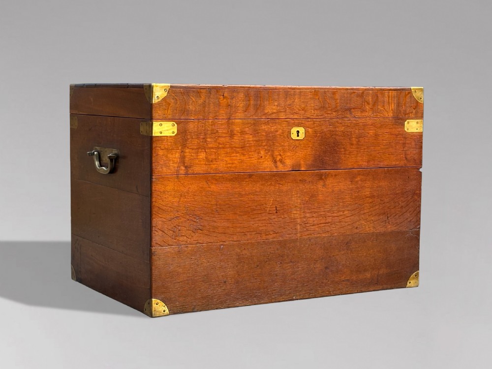 A large rectangular 19th-century oak travelling trunk featuring brass corner mounts, drop side handles, and an inlaid lid cartouche. View VIII