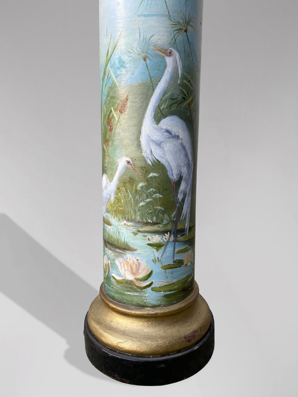 A pair of 19th-century French hand-painted cylindrical wooden columns featuring narrative desert and riverbank scenes above turned gilded bases. View V