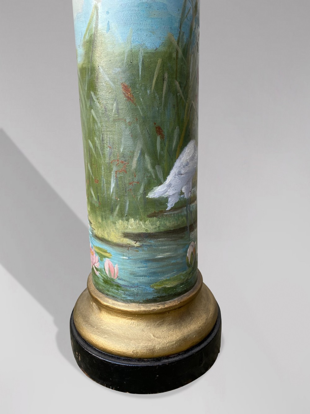 A pair of 19th-century French hand-painted cylindrical wooden columns featuring narrative desert and riverbank scenes above turned gilded bases. View VII