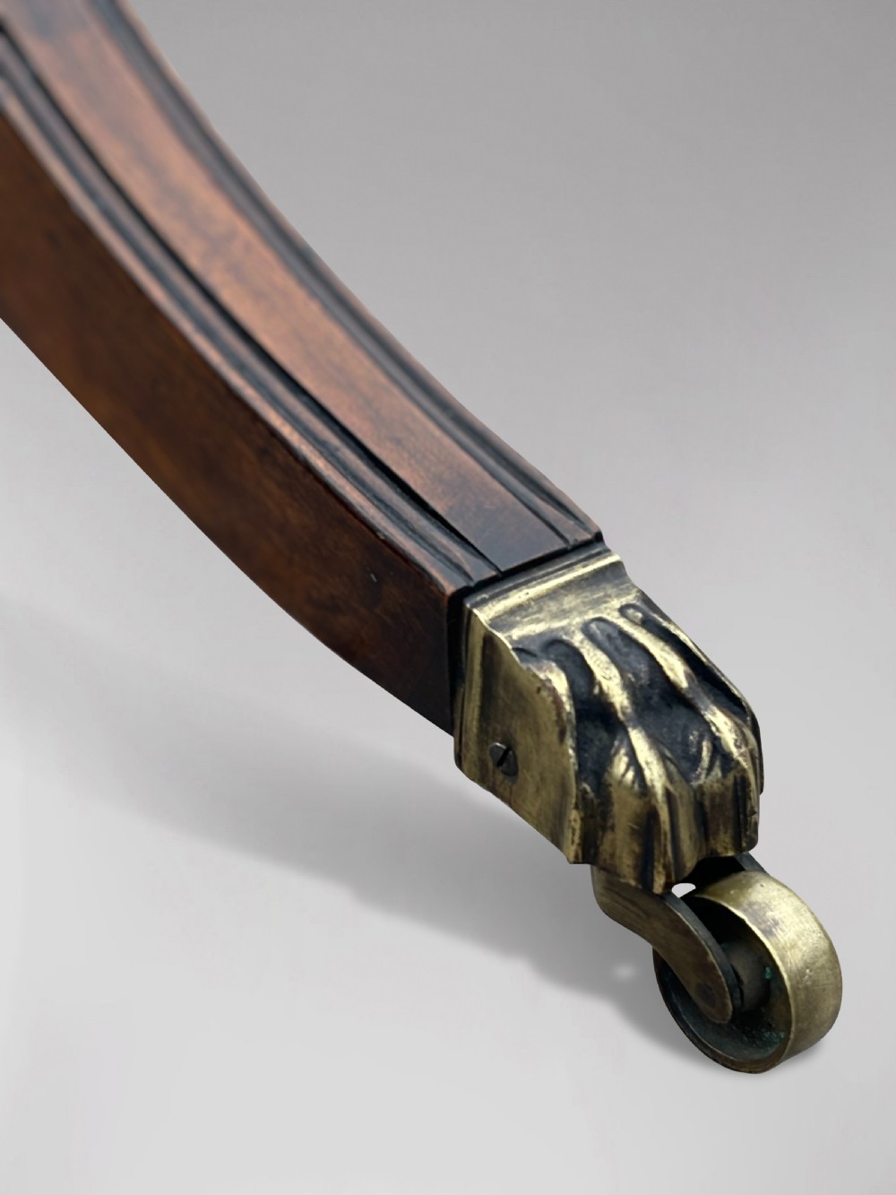A 19th-century circular mahogany drum table featuring a red leather inlaid top, brass lion mask handles on perimeter drawers, and a pedestal base on splayed legs with brass paw castors. View VIII