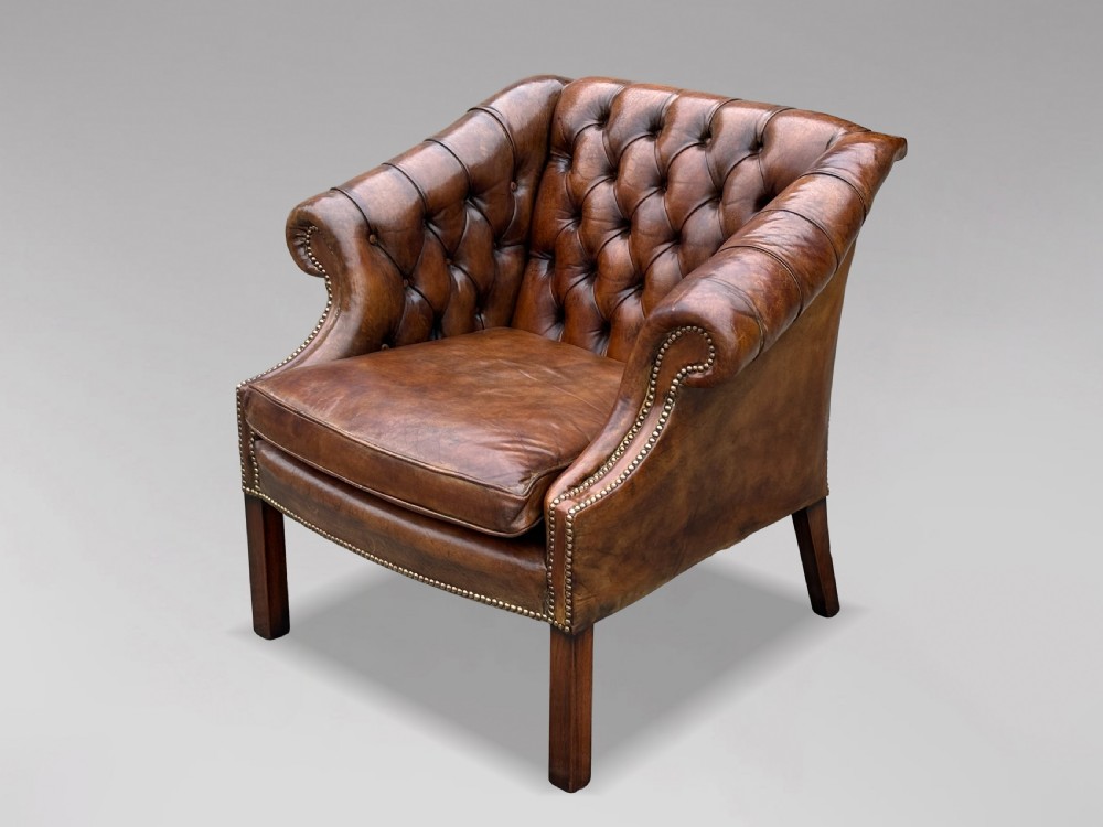 A 19th-century brown leather club armchair featuring deep button tufting, rolled arms with brass studding, and tapered timber legs. View VIII