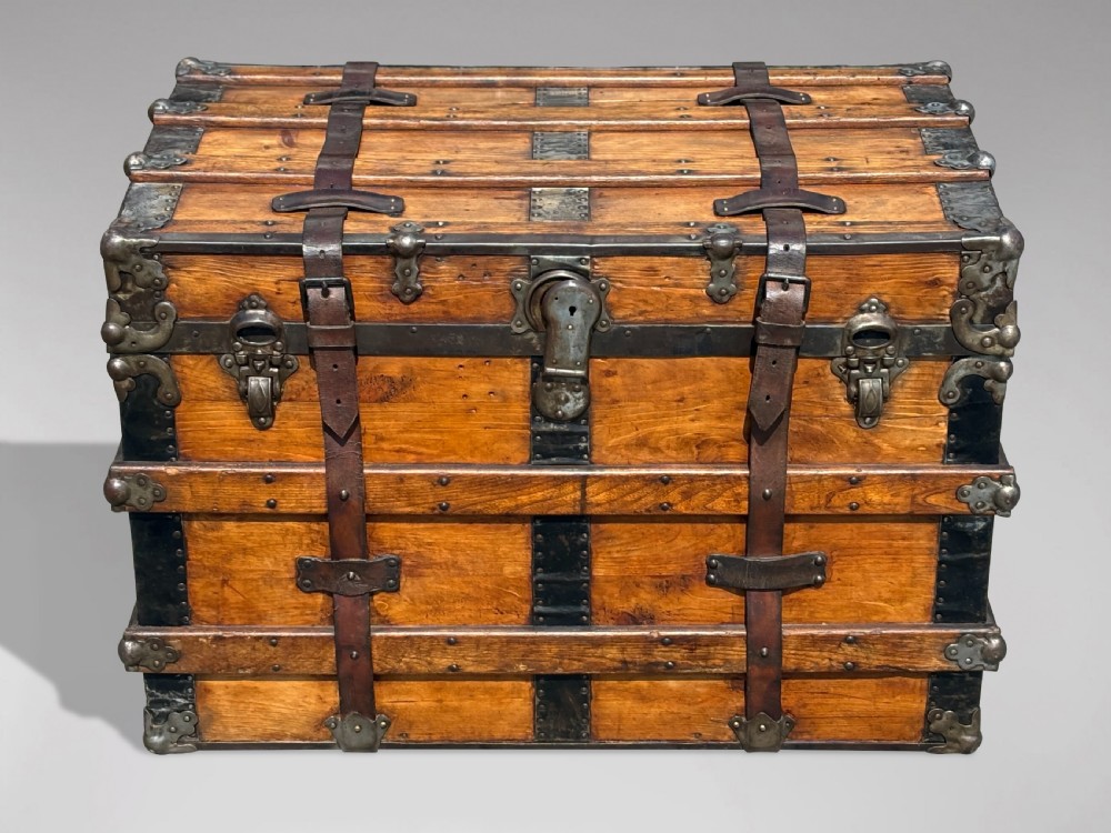 A 19th-century rectangular pine travelling trunk with metal corner protectors, horizontal wooden reinforcement slats, metal latches, and dual leather straps. View II