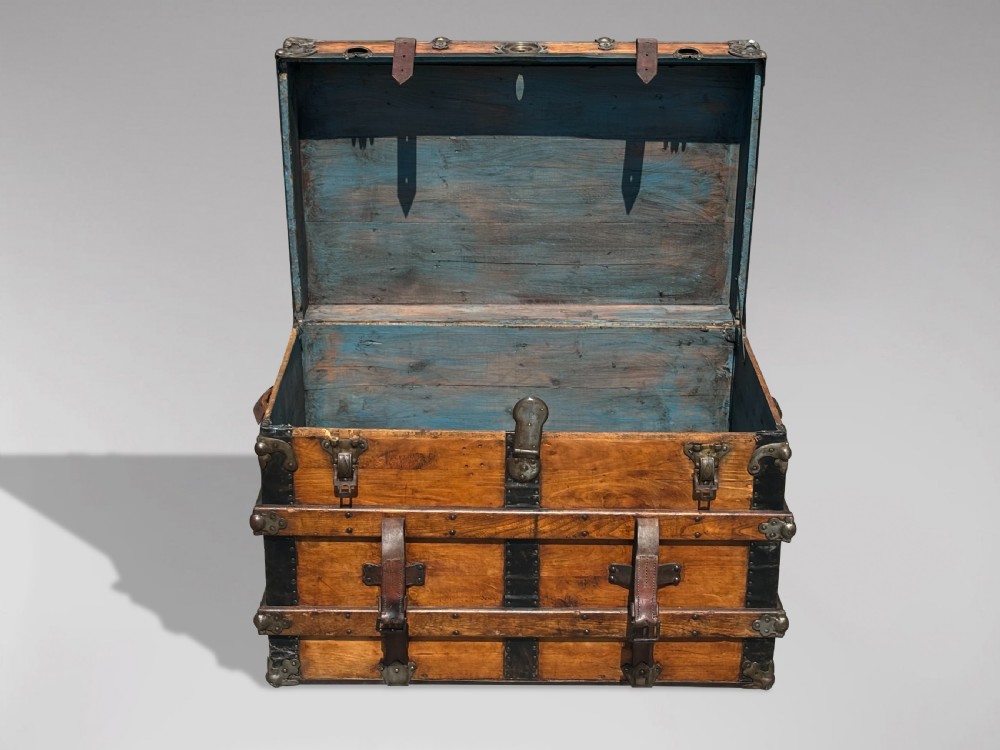 A 19th-century rectangular pine travelling trunk with metal corner protectors, horizontal wooden reinforcement slats, metal latches, and dual leather straps. View III