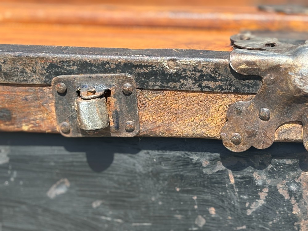 A 19th-century rectangular pine travelling trunk with metal corner protectors, horizontal wooden reinforcement slats, metal latches, and dual leather straps. View VII