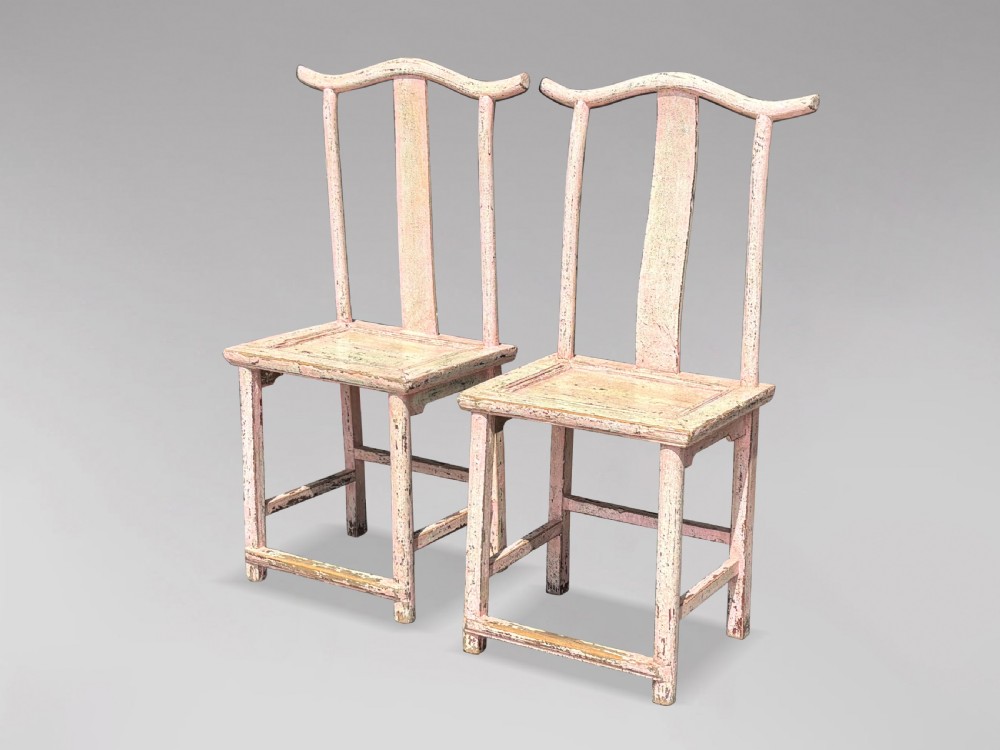 A pair of 19th-century Chinese yoke-back side chairs featuring a distressed pale pink painted finish, curved top rails, and central vertical back splats. View II