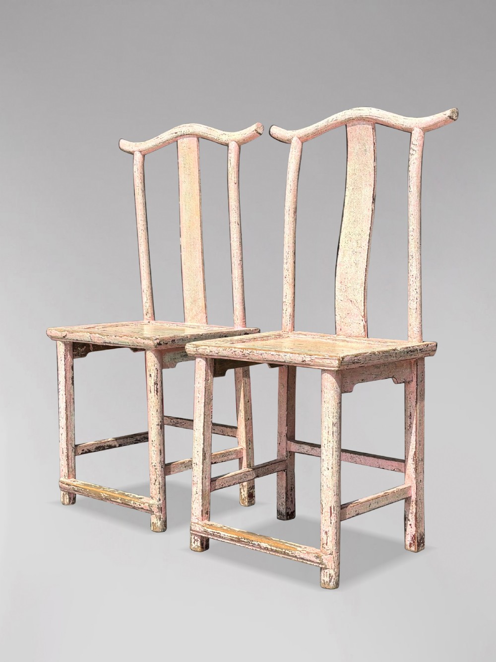 A pair of 19th-century Chinese yoke-back side chairs featuring a distressed pale pink painted finish, curved top rails, and central vertical back splats. View XI