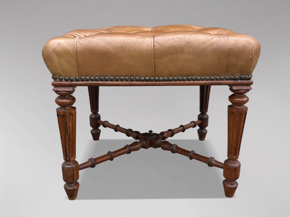 A 19th-century Regency period stool featuring a button-tufted tan leather seat with brass stud trimming, supported by turned fluted rosewood legs and turned stretchers. View III