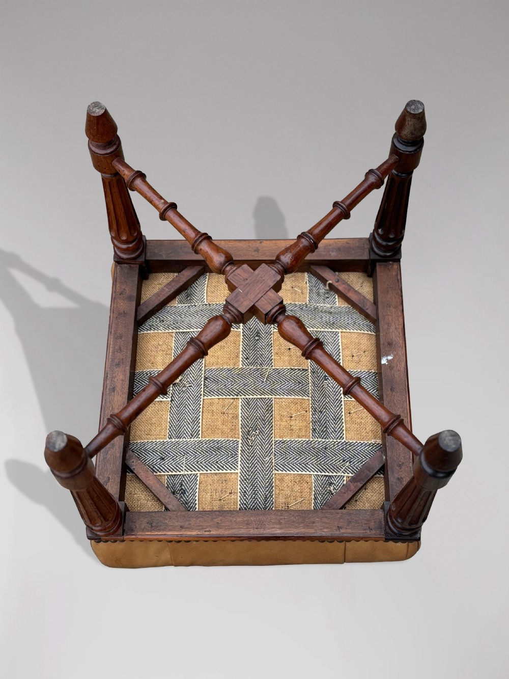 A 19th-century Regency period stool featuring a button-tufted tan leather seat with brass stud trimming, supported by turned fluted rosewood legs and turned stretchers. View VII