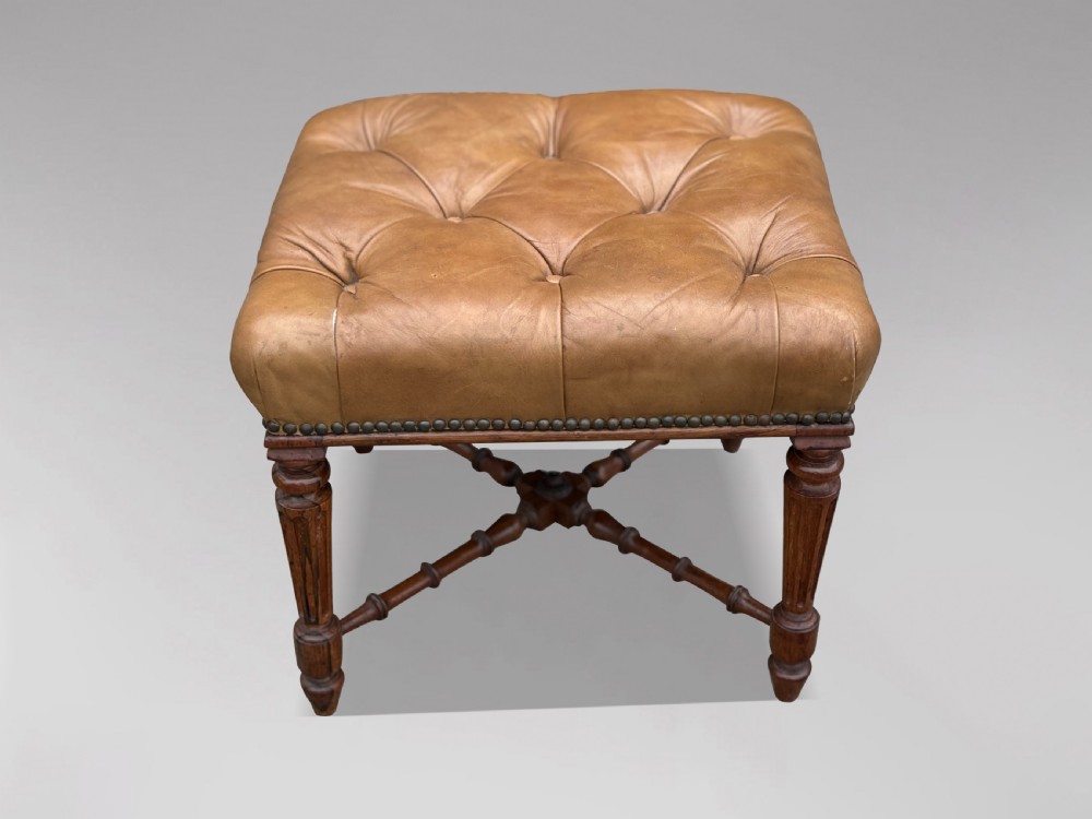 A 19th-century Regency period stool featuring a button-tufted tan leather seat with brass stud trimming, supported by turned fluted rosewood legs and turned stretchers. View VIII