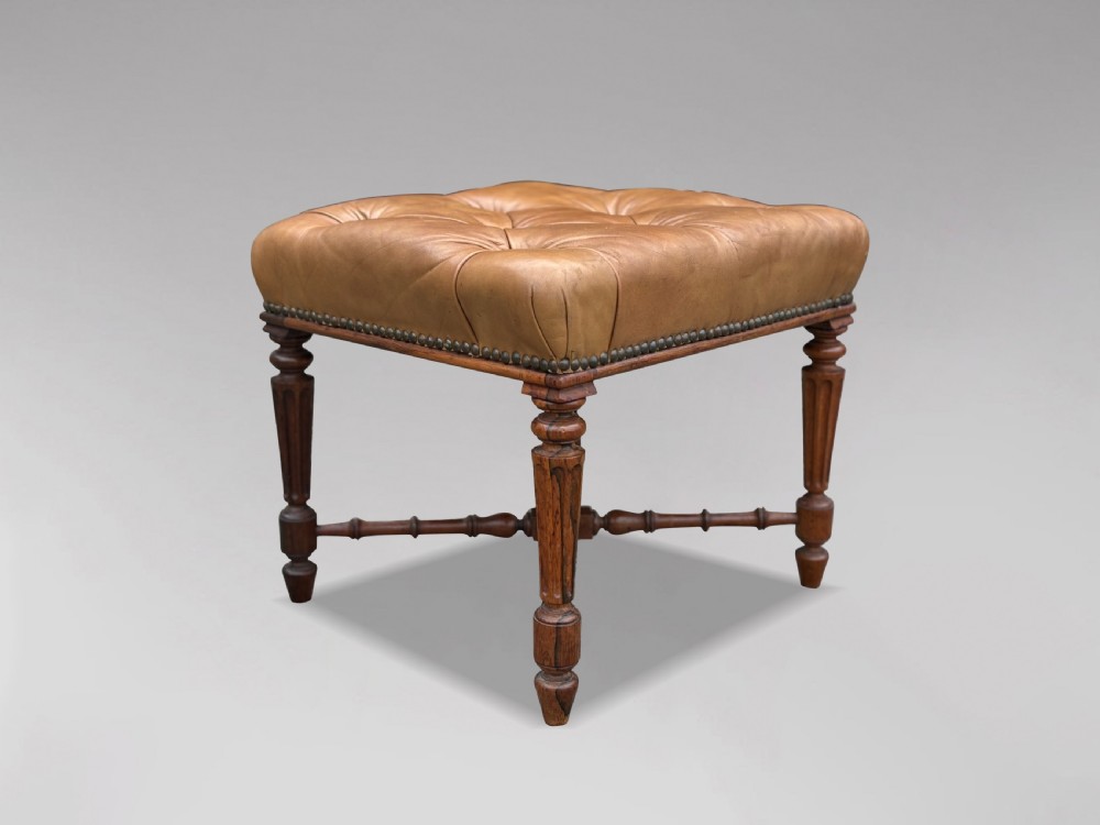 A 19th-century Regency period stool featuring a button-tufted tan leather seat with brass stud trimming, supported by turned fluted rosewood legs and turned stretchers. View IX