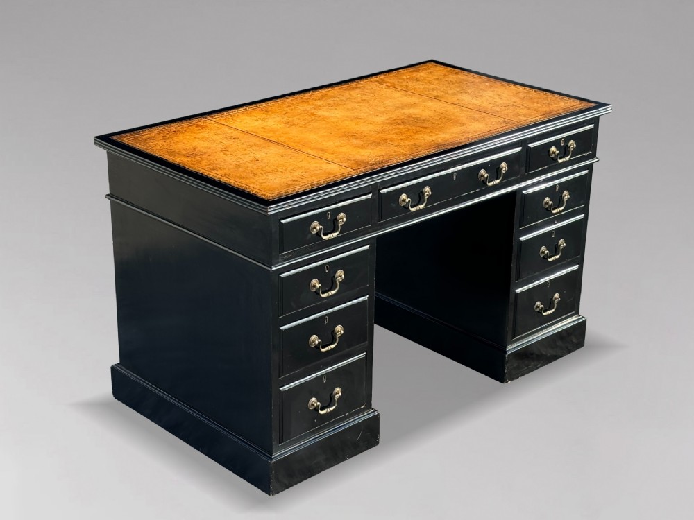 A 19th-century ebonised mahogany pedestal desk featuring a tan tooled leather inset top and brass swan-neck handles.