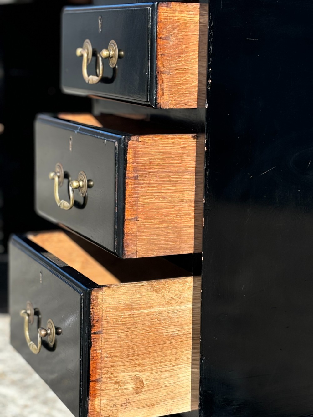 A 19th-century ebonised mahogany pedestal desk featuring a tan tooled leather inset top and brass swan-neck handles. View V