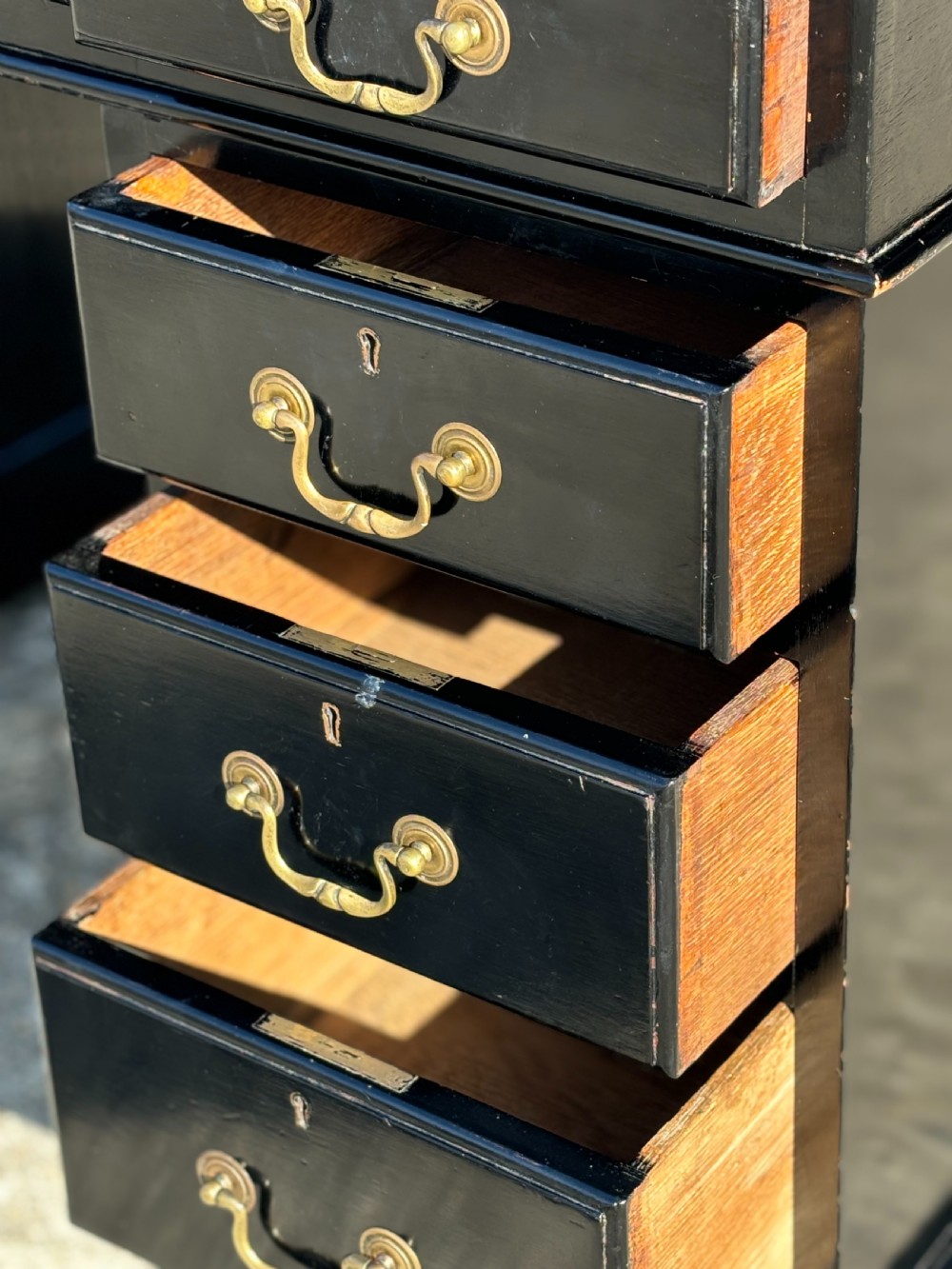 A 19th-century ebonised mahogany pedestal desk featuring a tan tooled leather inset top and brass swan-neck handles. View VI