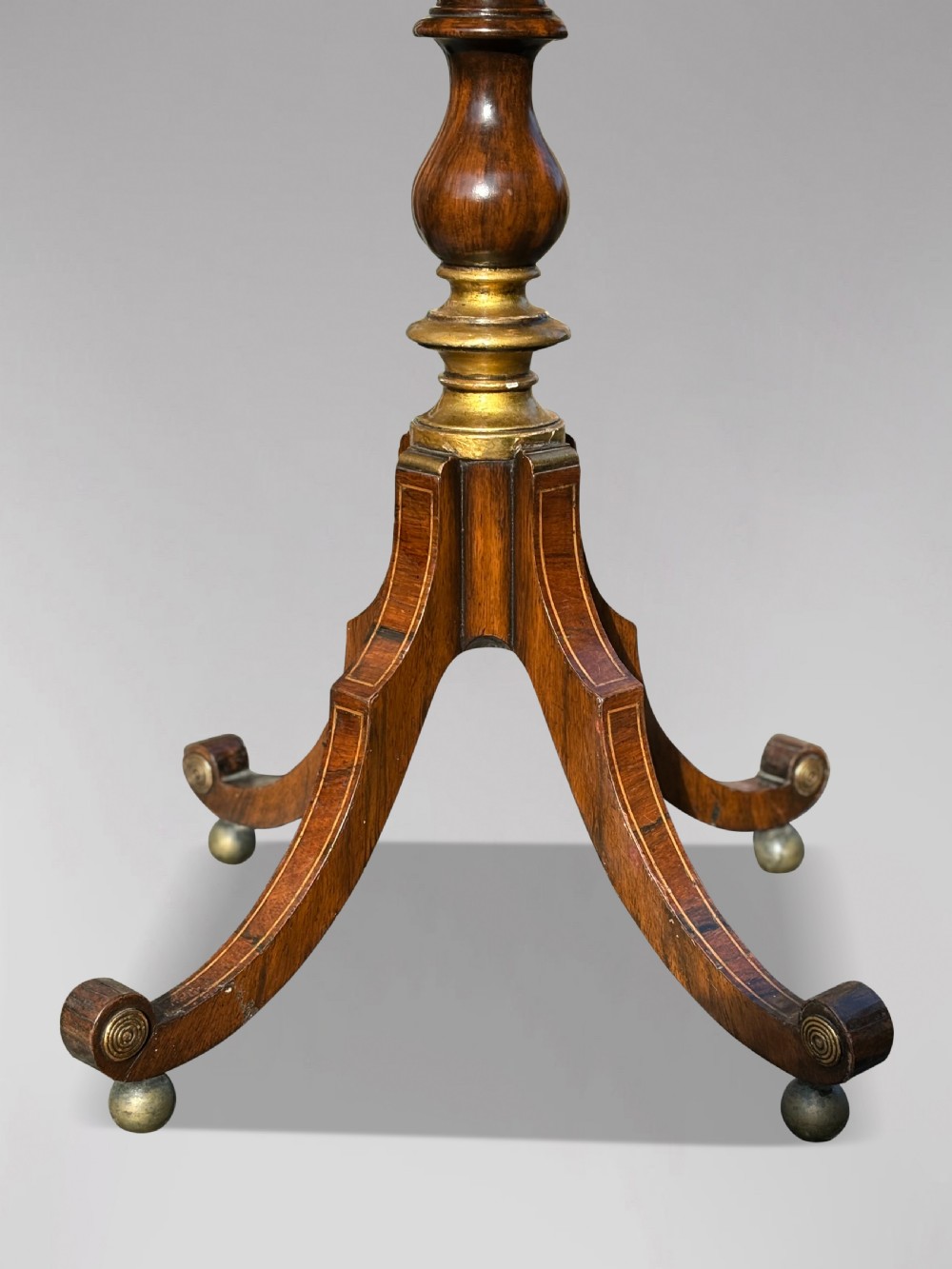 A 19th-century Regency rosewood circular work table featuring drawer fronts with brass knobs, a turned central stem, and a tripod base on ball feet. View VI