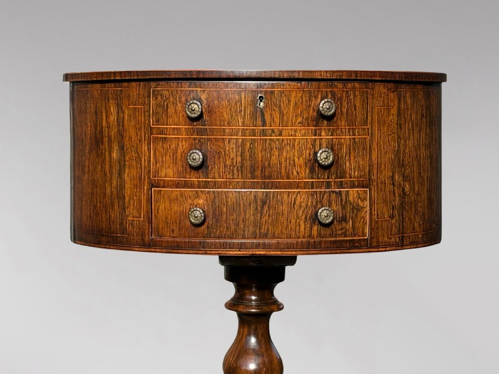 A 19th-century Regency rosewood circular work table featuring drawer fronts with brass knobs, a turned central stem, and a tripod base on ball feet. View XI