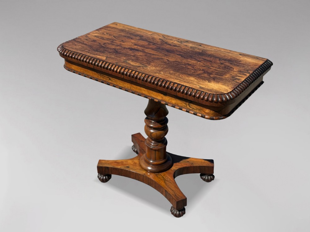 A 19th-century William IV rosewood fold-over card table featuring a gadrooned rim, a turned column stem, and a concave platform base with carved feet. View II