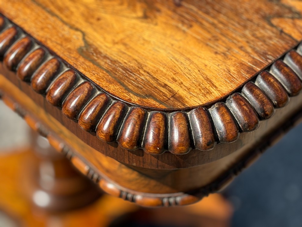 A 19th-century William IV rosewood fold-over card table featuring a gadrooned rim, a turned column stem, and a concave platform base with carved feet. View VI