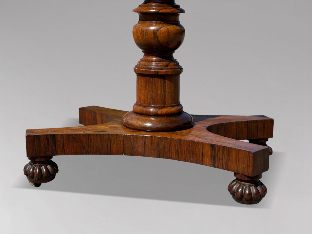 A 19th-century William IV rosewood fold-over card table featuring a gadrooned rim, a turned column stem, and a concave platform base with carved feet. View XI