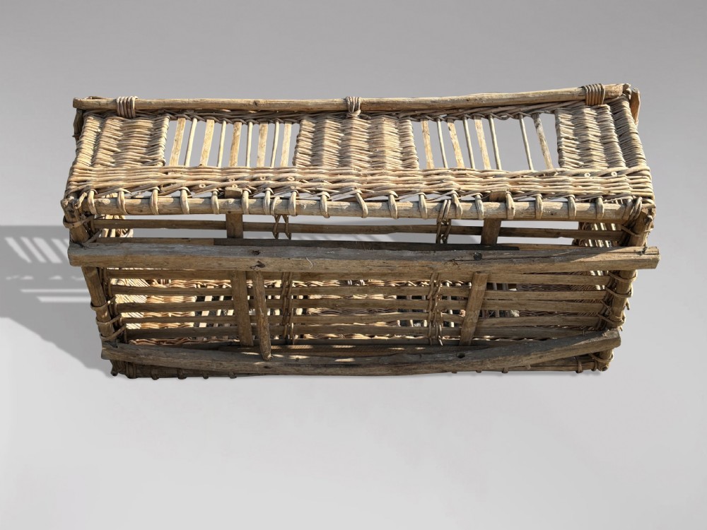 A large rectangular French wicker basket featuring open vertical weave, woven loop handles, and wooden runner skids along the base. View VIII