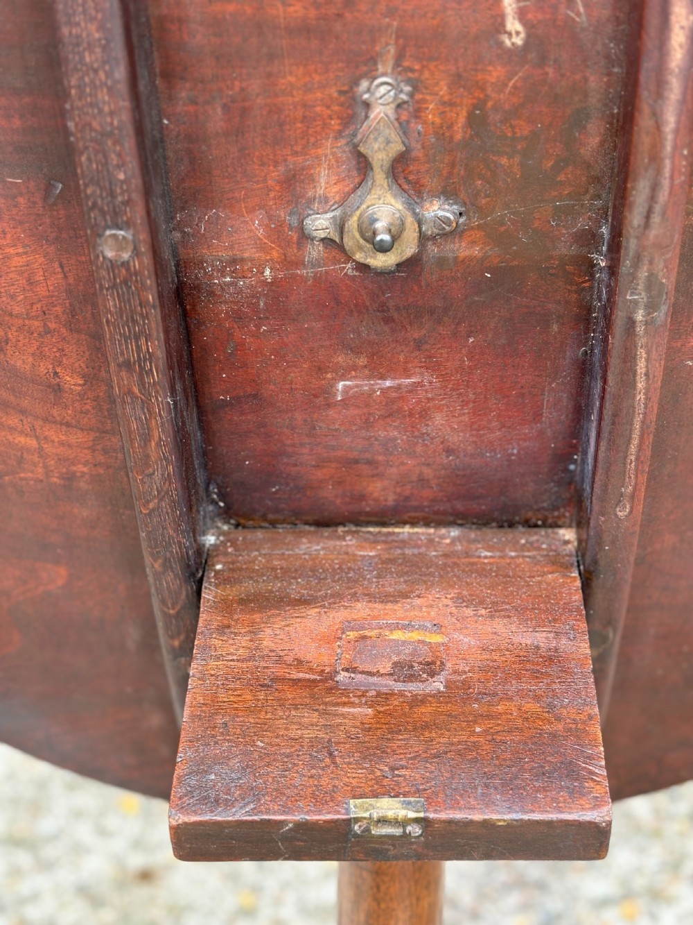 An 18th-century George III mahogany tripod table with its circular top tilted vertically above a turned central column and three cabriole legs. View VI